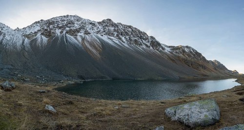 Lightly snow-covered mountains at Schottensee in autumn at the Flueela Pass