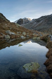 Lightly snow-covered mountains and mountain lake in autumn on the Flueela Pass