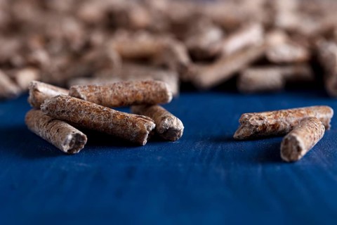 Wood pellets on a blue wooden background