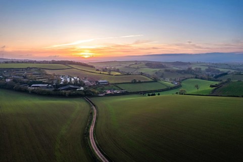 Sunset over fields and Widdicombe Farm from a drone