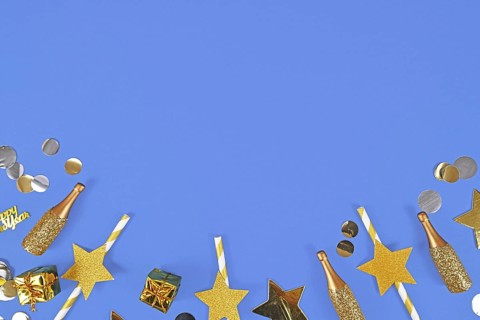 New year flat lay with golden party items on blue background with copy space
