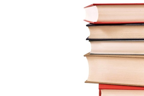 Stack of old hardcover books on side of white background with copy space