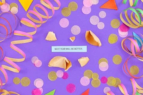 Motivational New Year celebration concept with open fortune cookie and text Next year will be great on colorful background with paper streamers and confetti