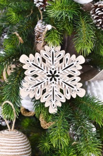 Christmas tree branch with natural wooden snowflake ornament