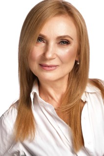 Portrait of a beautiful elderly woman in a white shirt with classic makeup and blond hair