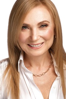 Portrait of a beautiful elderly woman in a white shirt with classic makeup and blond hair
