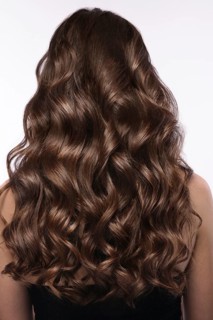 A closeup view of a bunch of shiny curls brown hair