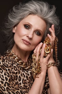 Portrait of a beautiful elderly woman in a leopard blouse with classic makeup and gray hair