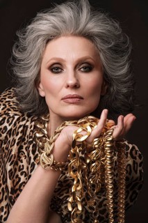 Portrait of a beautiful elderly woman in a leopard blouse with classic makeup and gray hair