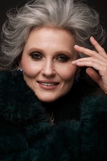Portrait of a beautiful elderly woman in a leopard blouse and fur coat with classic makeup and gray hair