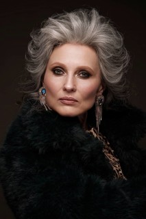 Portrait of a beautiful elderly woman in a leopard blouse and fur coat with classic makeup and gray hair
