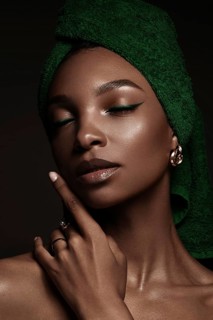 Beautiful black woman with a green towel on her head and classic make-up. Beauty face. Photo taken in the studio