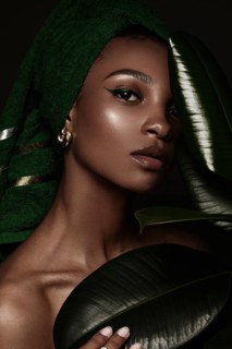Beautiful black woman with a green towel on her head and classic make-up. Beauty face. Photo taken in the studio