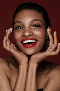 Beautiful black woman with a smile and red lips and freckles. Beauty face. Photo taken in the studio