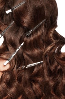 A closeup view of a bunch of shiny curls brown hair