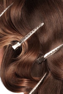 A closeup view of a bunch of shiny curls brown hair