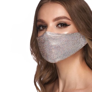 Portrait of a beautiful woman in a silver mask with rhinestones and classic makeup. Mask mode during the covid pandemic