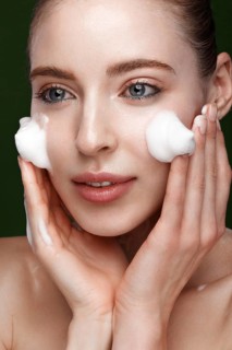 Beautiful young girl with cream on the skin. Beauty face. Picture taken in the studio