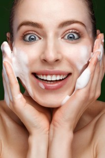 Beautiful young girl with cream on the skin. Beauty face. Picture taken in the studio