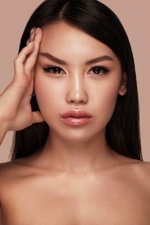 Beautiful delicate woman of oriental type with nude makeup and perfect skin. Beauty face. Spa salon