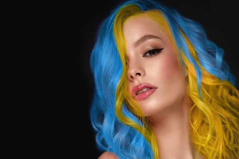 Portrait of beautiful woman with blue and yellow hair and classic make up and hairstyle