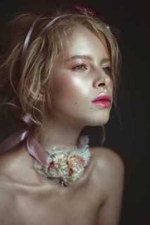 Beautiful blond fashion girl with flowers on the neck and in her hair
