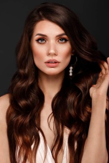 Beautiful brunette woman with curls and classic make-up. Beauty face. Photo taken in studio