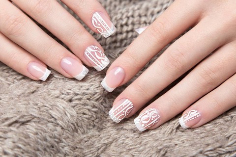 Snow White manicure on female hands. Winter nail design. Picture taken in the studio on a background of wool