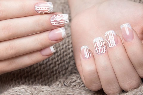 Snow White manicure on female hands. Winter nail design. Picture taken in the studio on a background of wool