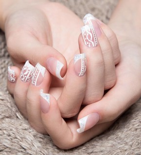Snow White manicure on female hands. Winter nail design. Picture taken in the studio on a background of wool