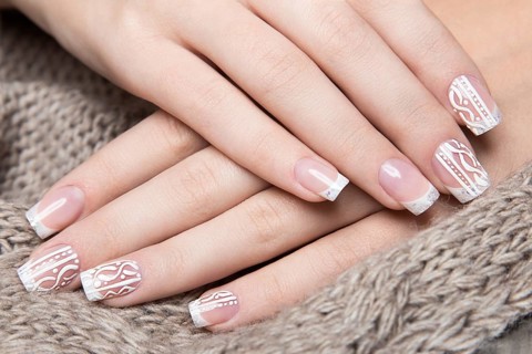 Snow White manicure on female hands. Winter nail design. Picture taken in the studio on a background of wool