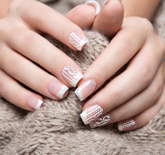 Snow White manicure on female hands. Winter nail design. Picture taken in the studio on a background of wool