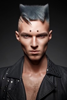 Young man with blue hair and creative makeup and hair. Photo taken in the studio