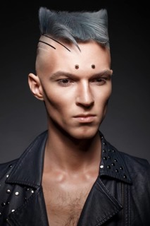 Young man with blue hair and creative makeup and hair. Photo taken in the studio