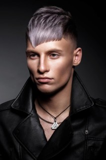 Young man with purple hair and creative makeup and hair. Photo taken in the studio