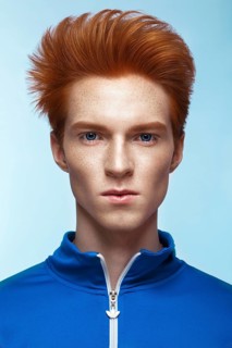 Young man with red hair and creative make up and hair. Photo taken in the studio