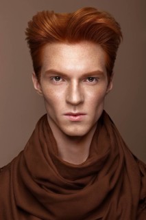 Young man with red hair and creative make up and hair. Photo taken in the studio