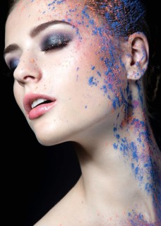 Portrait of a beautiful Girl with red paint on her face. Photo shot in the Studio on a black background