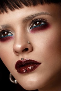 A beautiful girl with art creative make-up and earrings on the face. Photos shot in studio