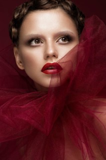 Beautiful girl with art creative make-up in the image of a red bride for Halloween. Beauty face. Photo taken in studio