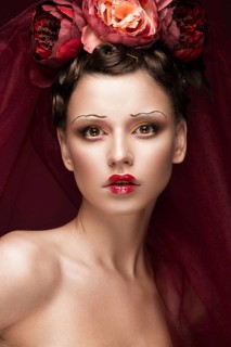 Beautiful girl with art creative make-up in the image of a red bride for Halloween. Beauty face. Photo taken in studio