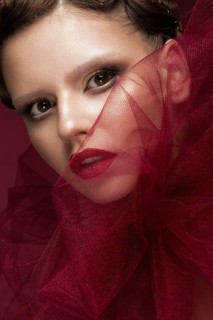 Beautiful girl with art creative make-up in the image of a red bride for Halloween. Beauty face. Photo taken in studio
