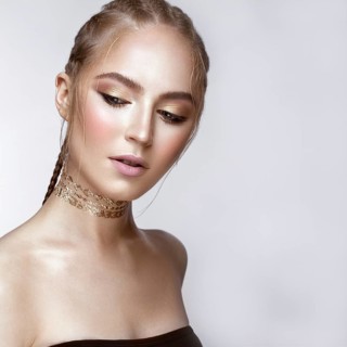 Beautiful girl with a golden shiny make-up and a haircut on her head. Beauty face. Photo taken in the studio