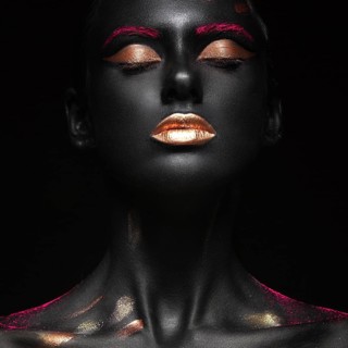 Fashion portrait of a dark-skinned girl with color make-up.Beauty face. Picture taken in the studio on a black background