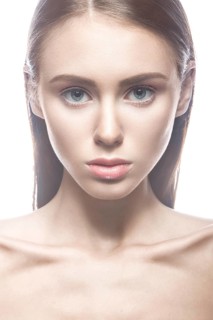 Beautiful girl with a light Nude make-up and blond hair. Beauty face. Picture taken in the studio on a white background
