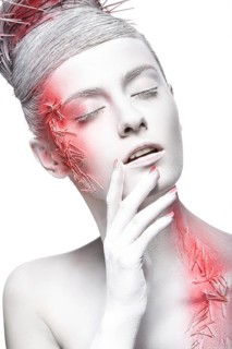 Art fashion girl with white skin and red paint on the face. Creative art beauty. Picture taken in the studio on a black background