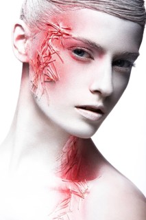 Art fashion girl with white skin and red paint on the face. Creative art beauty. Picture taken in the studio on a black background