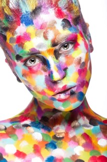 Girl with colored face painted. Art beauty image. Picture taken in the studio on a white background