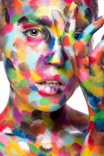 Girl with colored face painted. Art beauty image. Picture taken in the studio on a white background