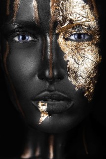 Fashion portrait of a dark-skinned girl with gold make-up.Beauty face. Picture taken in the studio on a black background
